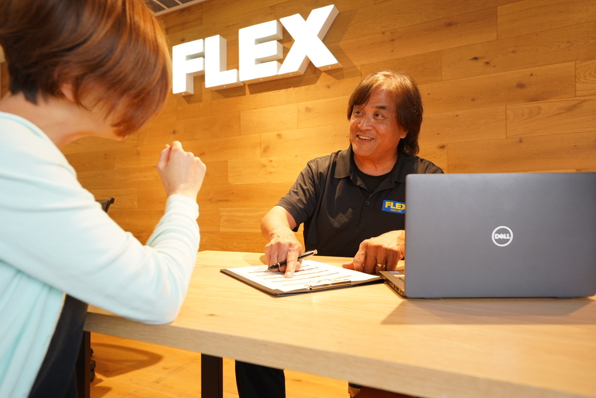 A staff explaining a purchase plan to a customer at FLEX Automotive in San Diego