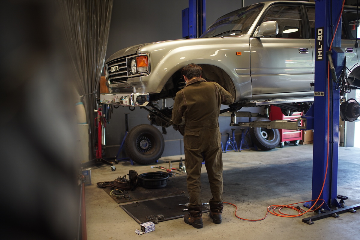 A mechanic installing a Renoca kit onto a Land Cruiser at FLEX Automotive in San Diego