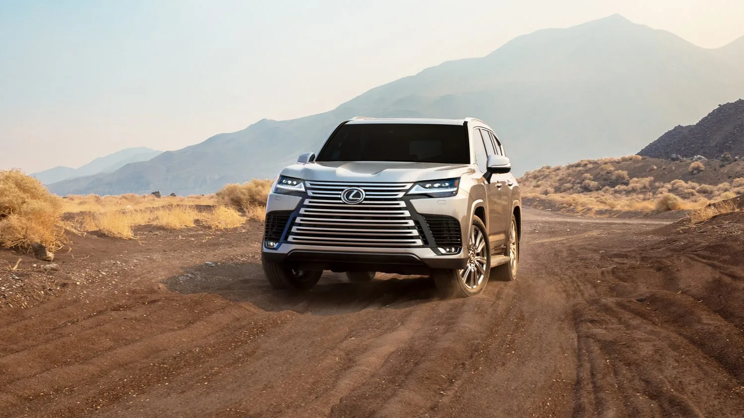 2024 Lexus LX 600 driving on a scenic winding road demonstrating composure and handling
